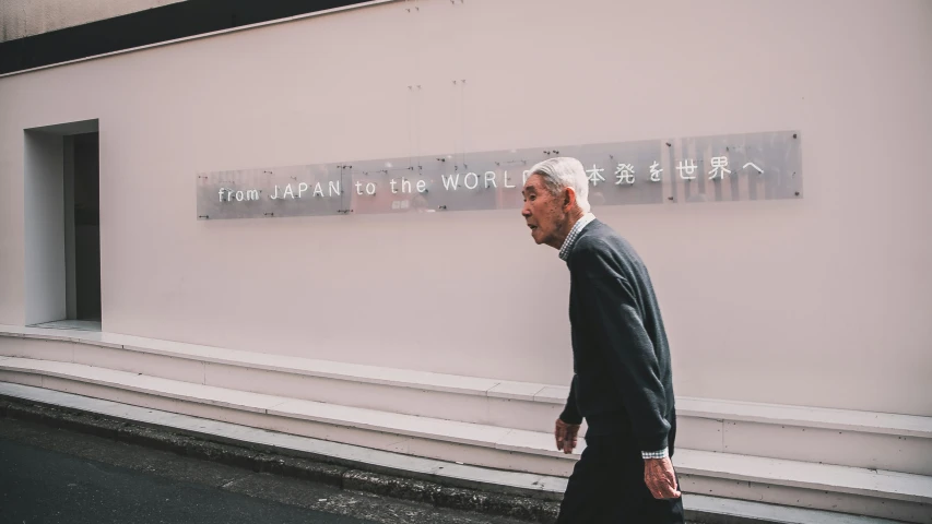 the man is walking towards a sign on the wall