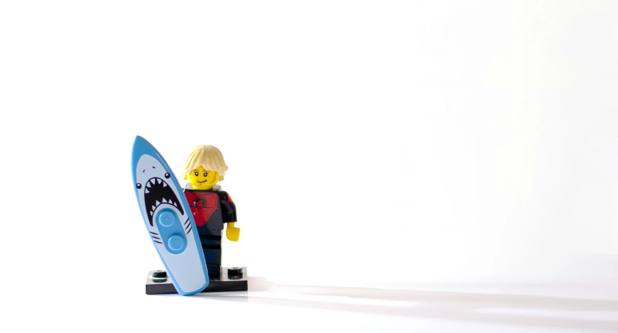 a toy figurine holding a blue surfboard