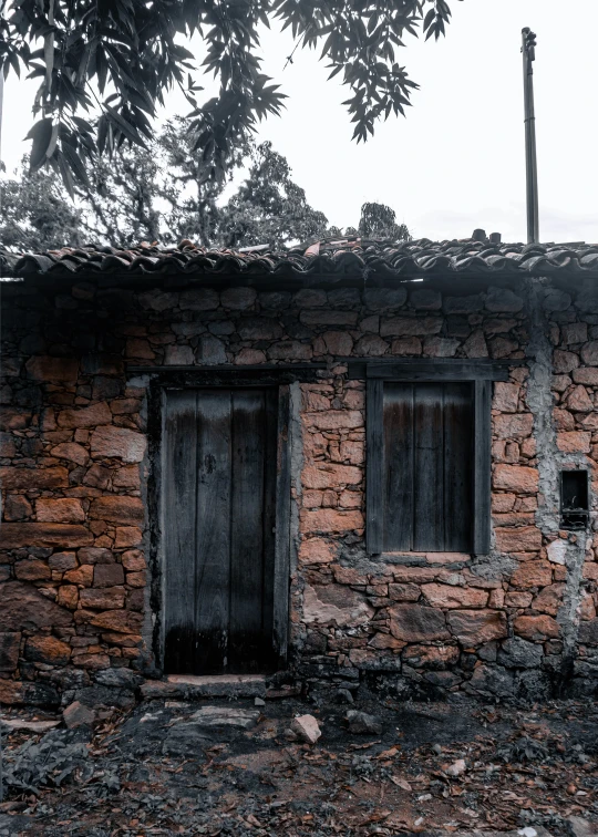 an old stone and wooden building that has broken windows