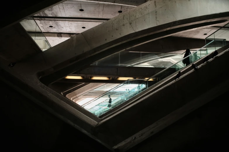 two people are standing on the escalator