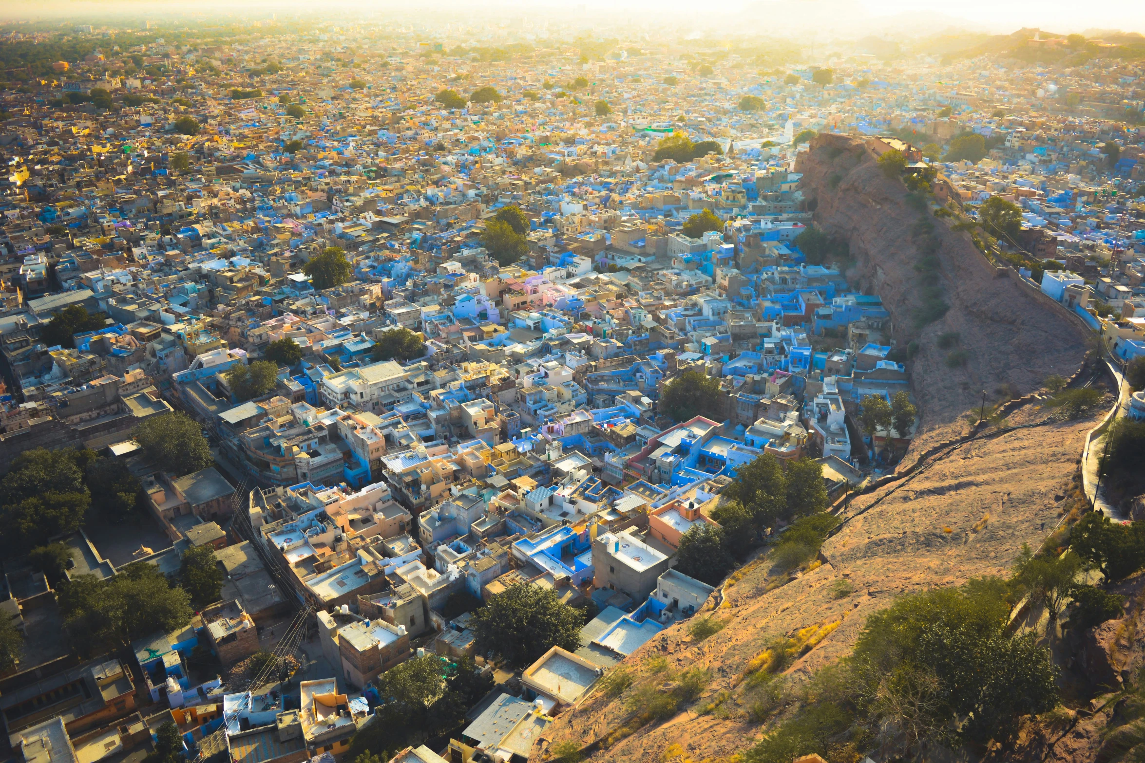 an aerial view of a city with mountains in the background