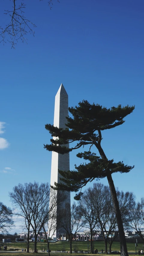a tall white obelisk standing under a blue sky