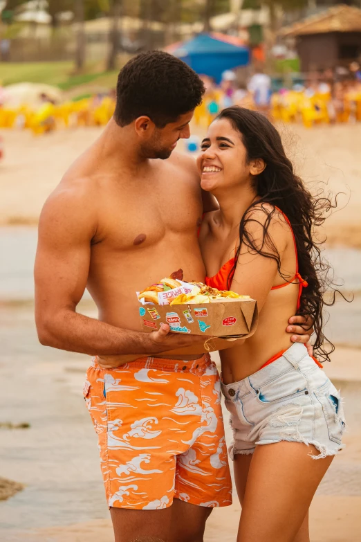 a man and woman standing next to each other on the beach