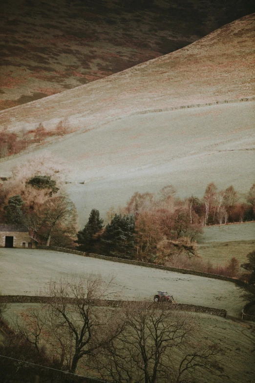 an empty field below the hills is seen with some mist