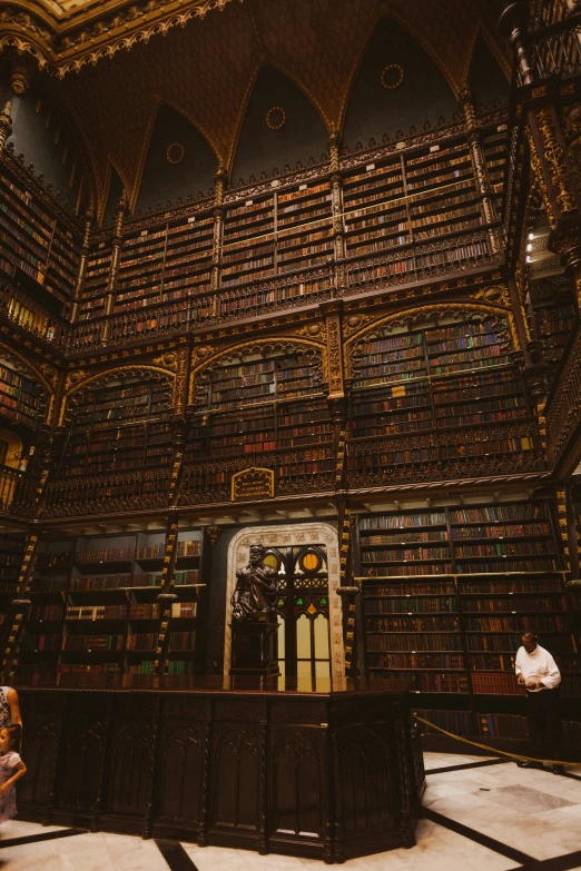 the people sit near the shelves in a large liry