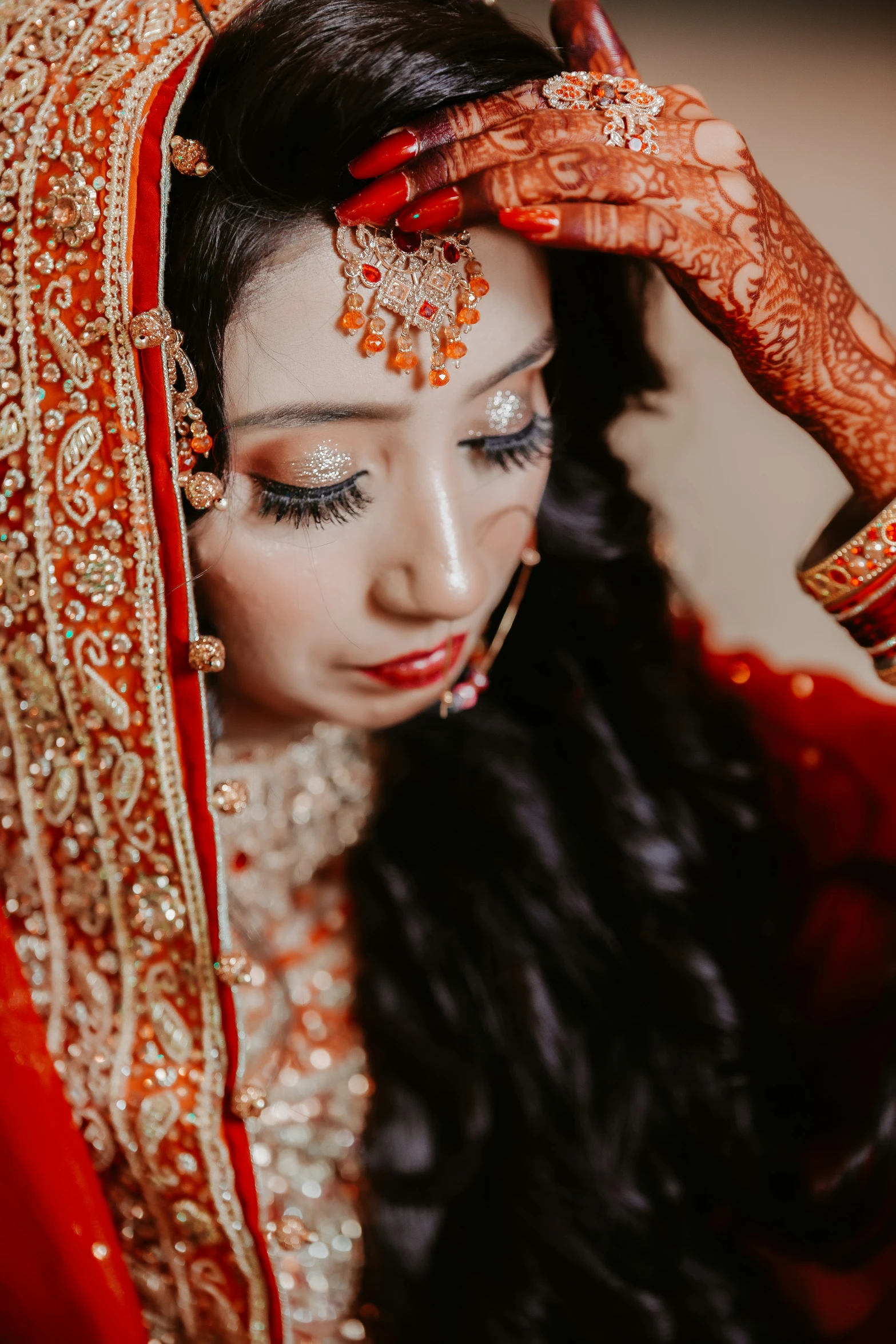 a woman in a red bridal veil wearing an indian dress