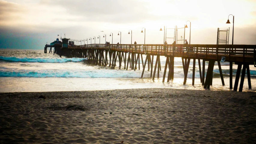 a long pier sits above the ocean waves