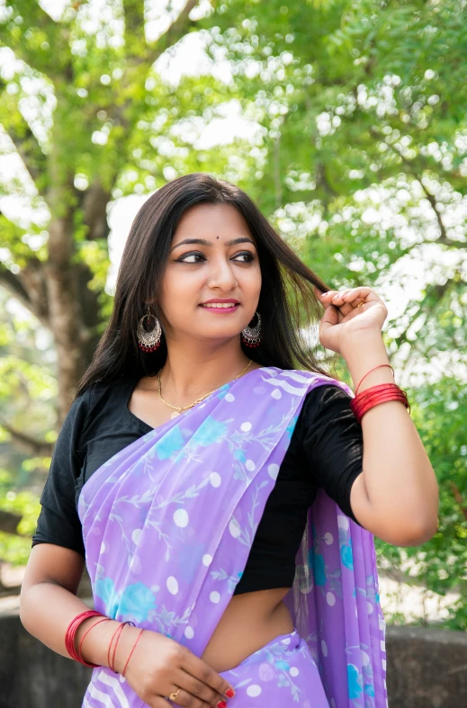 the woman in blue sari is posing with her hands on her hair