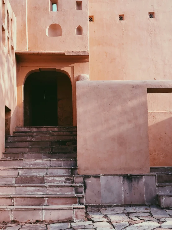 stairs leading to a tall building with several windows