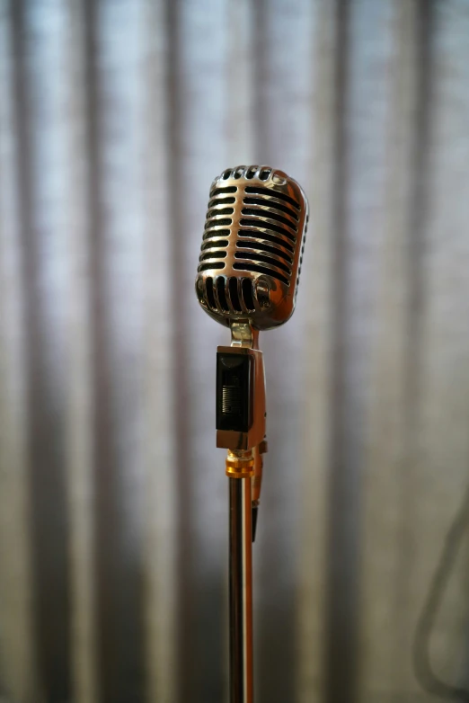 an old microphone on a stand with a striped wall behind it