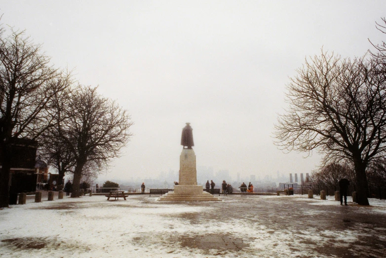 a clock tower surrounded by bare trees covered in snow