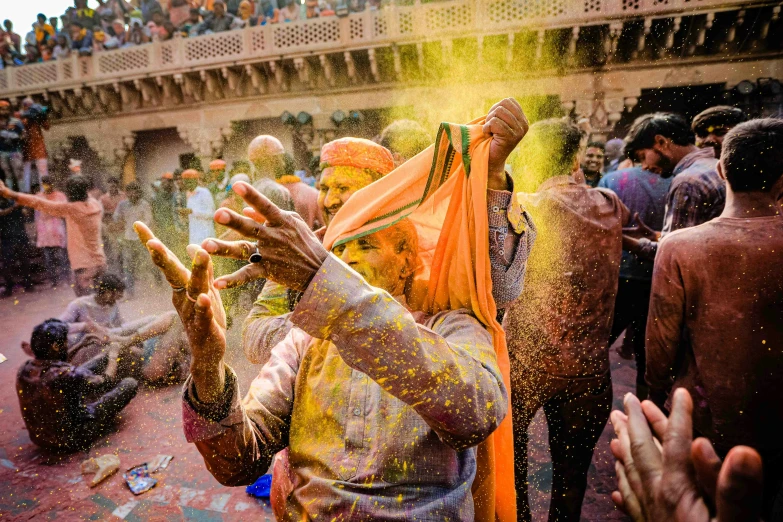 a man being sprayed with colorful powder at a festival