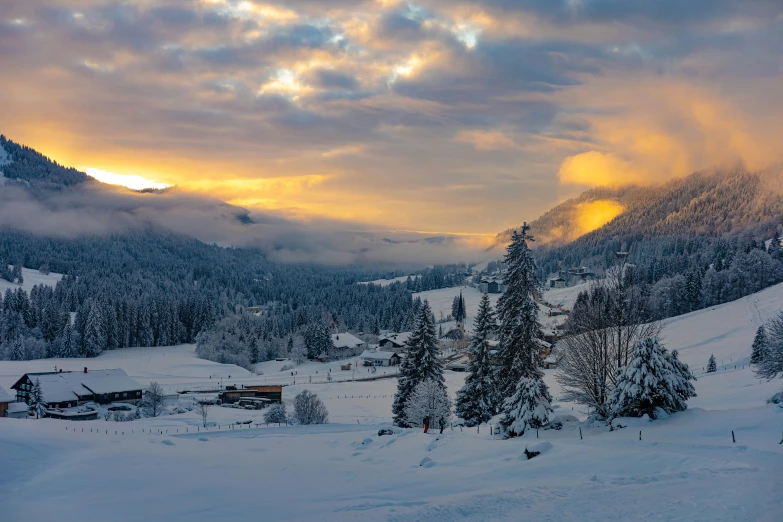 the sun rises on a snowy mountain with a cabin