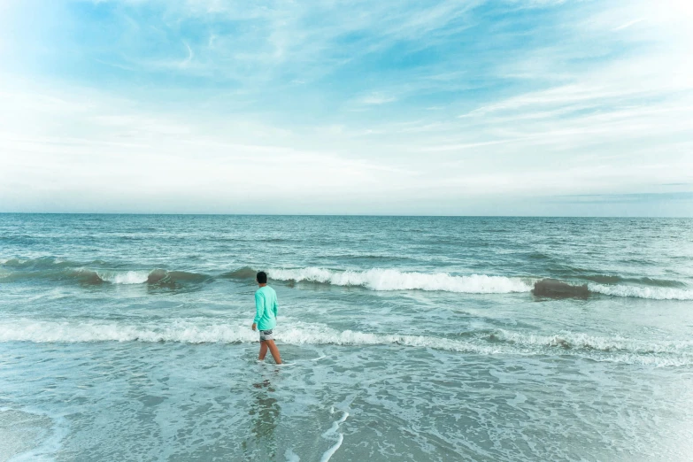 a person standing in the shallow ocean waves