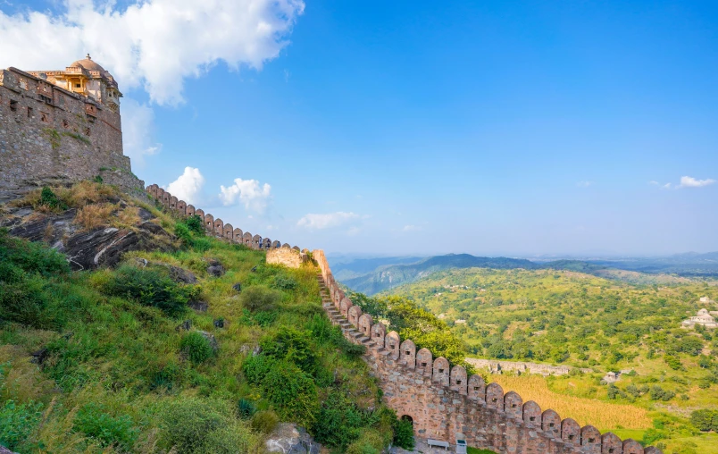 a huge wall sits atop of a hill