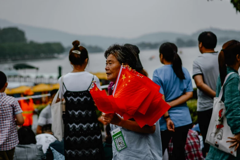 an asian woman wearing a red coverall looks off to the side