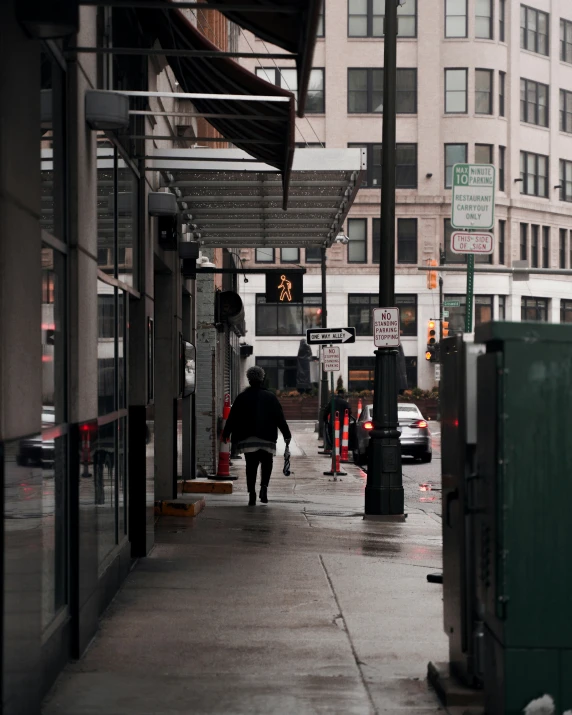 a man walking down a street under a umbrella