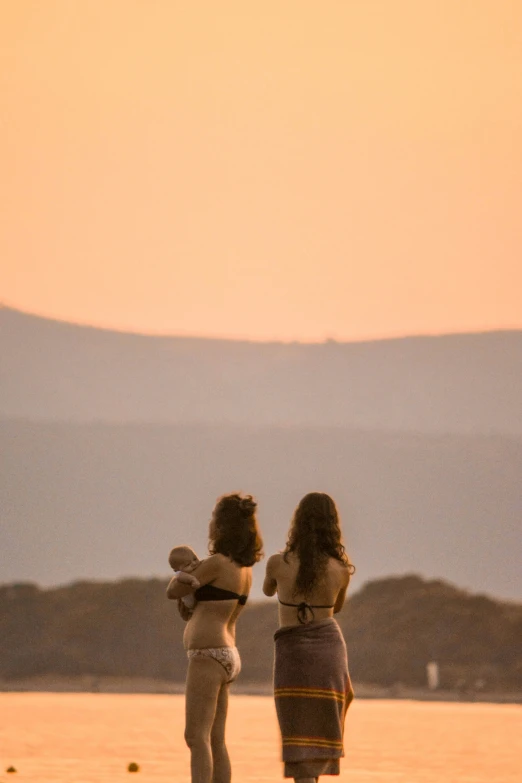 two women that are walking on the beach