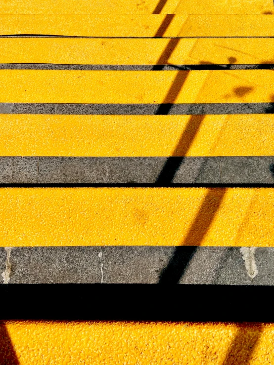 a sidewalk with yellow steps painted on the side