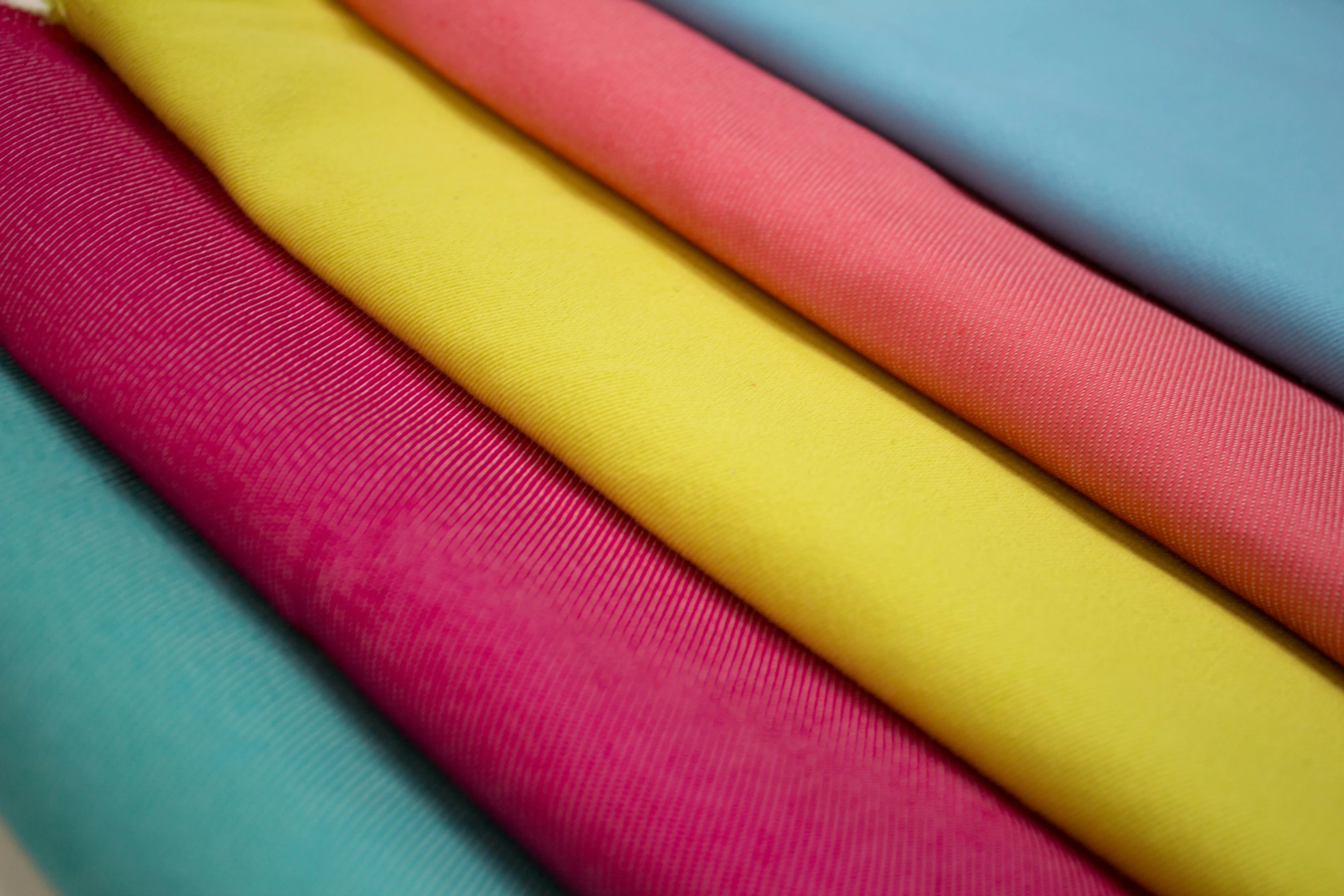 many different colored fabrics are stacked next to each other