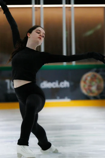 female figure skating on ice in indoor rink