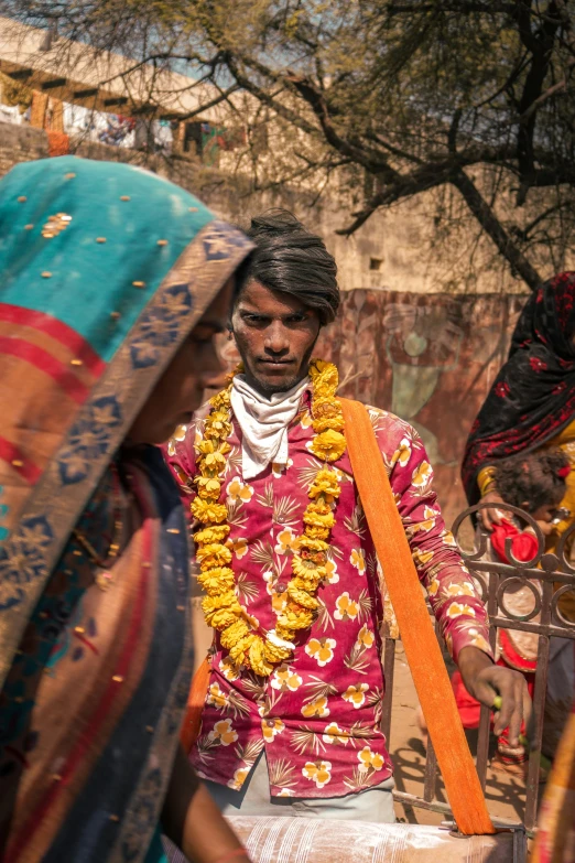 man and woman in floral attire with garland on their head