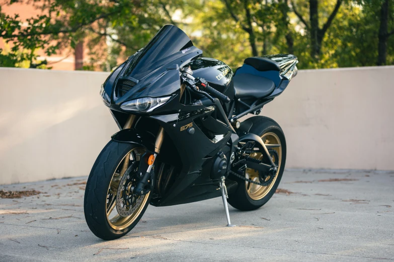 the motorcycle is parked on the road near a wall