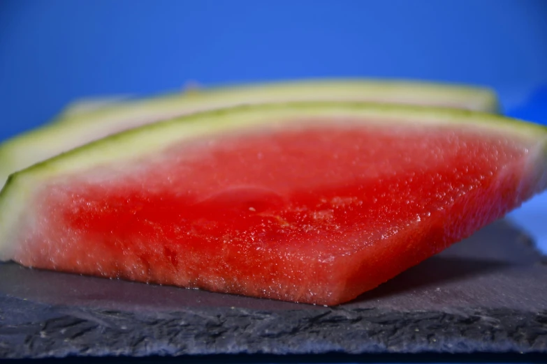 a wedge of watermelon resting on a slate