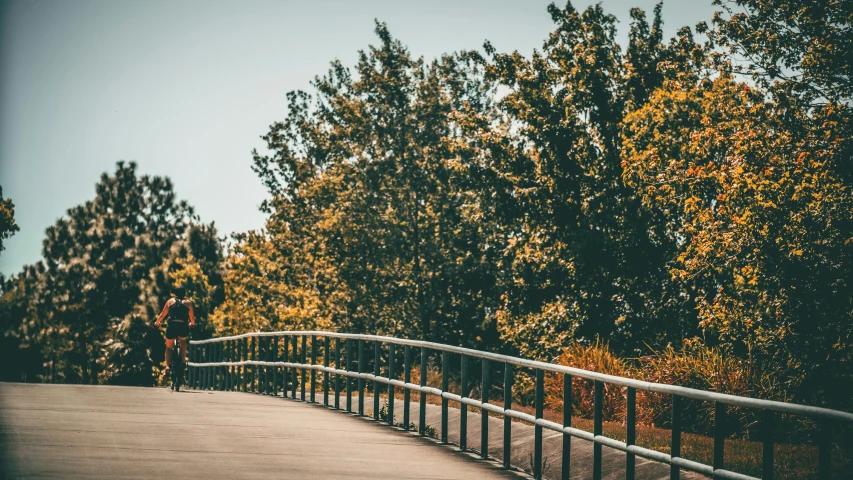 two people walking down the bridge while another person walks