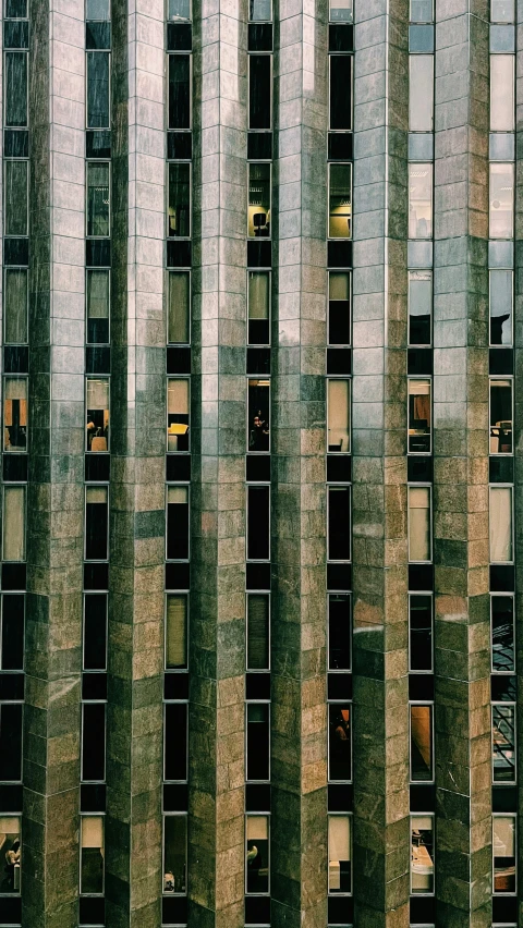 a very tall building with many windows and some people on the side