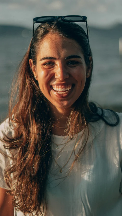 a woman with sunglasses on and long hair smiling