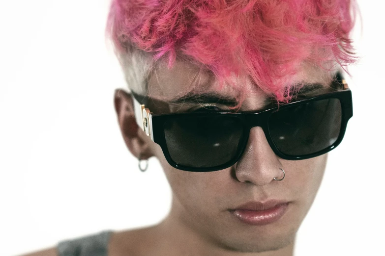 a person with bright pink hair wearing sunglasses