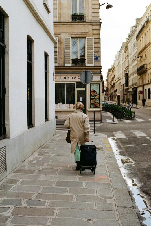 a man is walking down the street pulling a suitcase