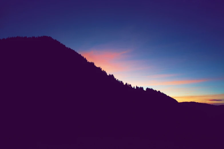 an image of the sun setting over a mountain