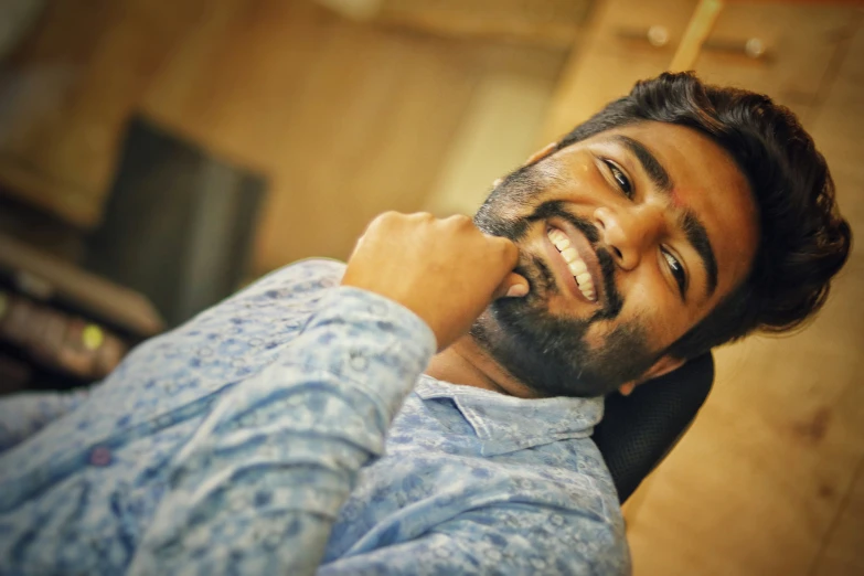 man smiling with beard and blue shirt on