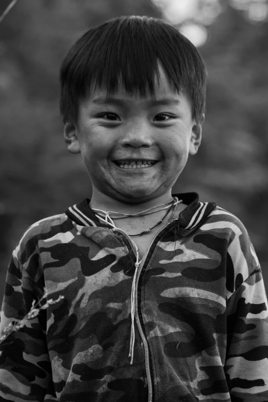 a young child is smiling in a black and white po
