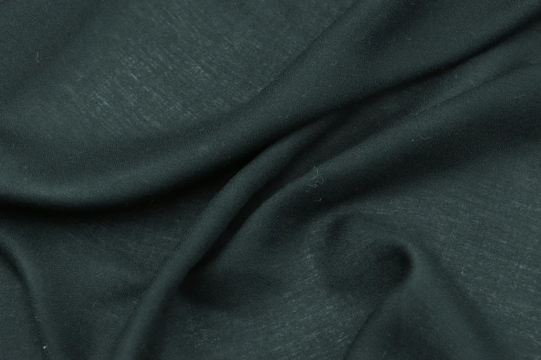 closeup image of the texture of dark green, plain fabric