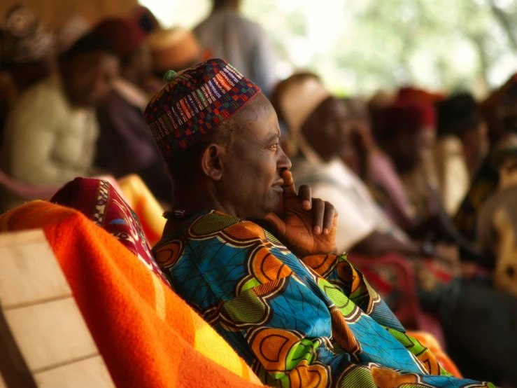 a man with a hat sitting on a bench