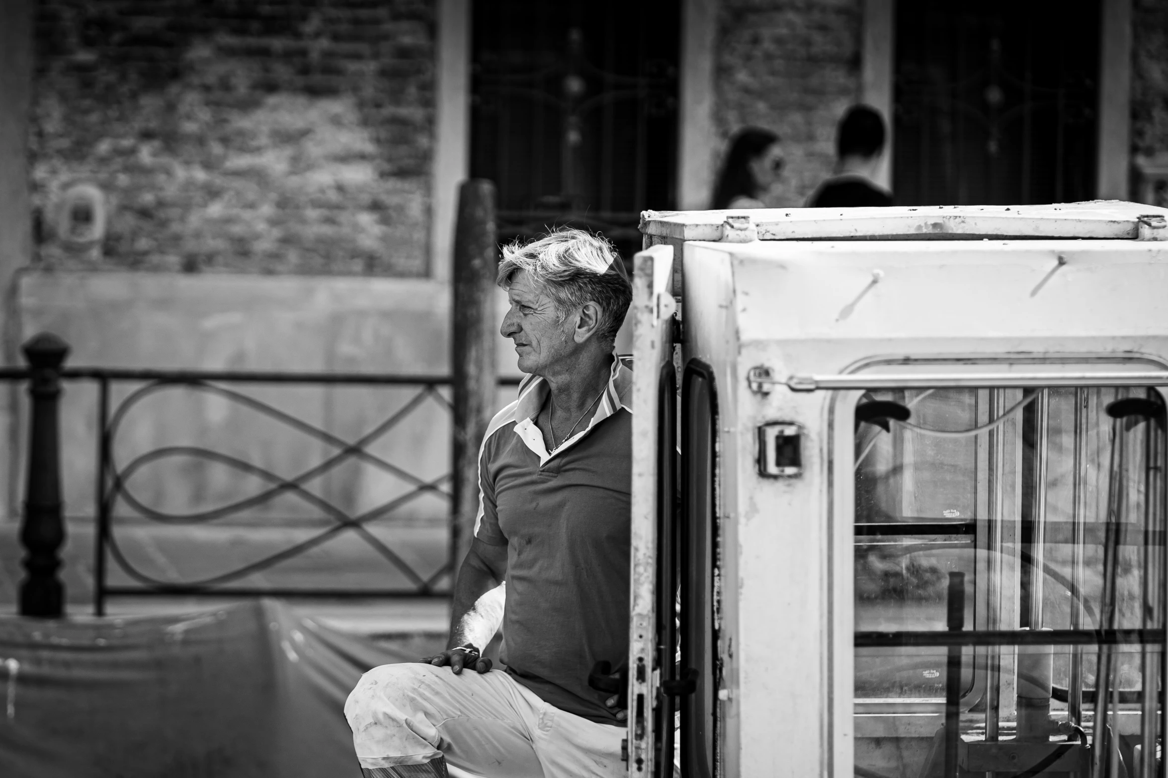 a man sitting at the doorway of his bus