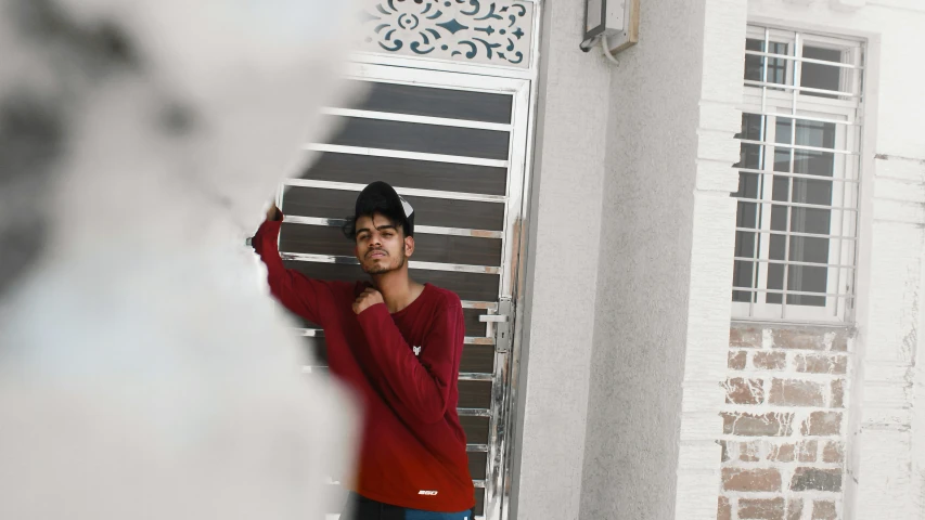 a man is leaning against a building near the wall