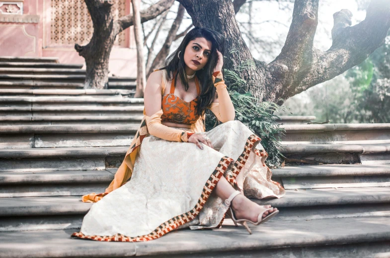 a woman sits on the steps in a dress