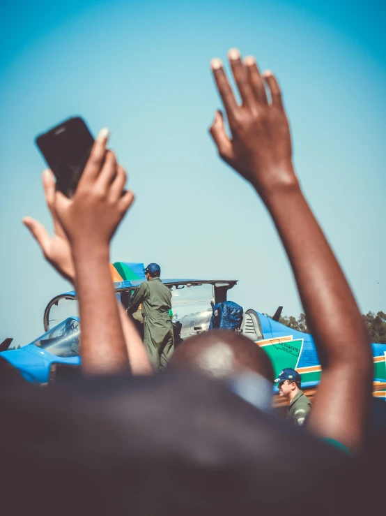 two hands held in the air above a car