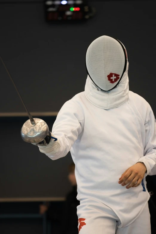 a man in white fencing outfit holding a ball and a string