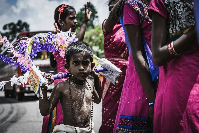 two boys with smeared body paint stand next to a woman