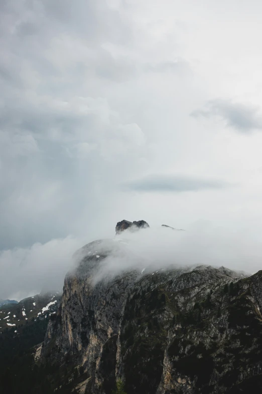 mountains and clouds cover a sky with some hills