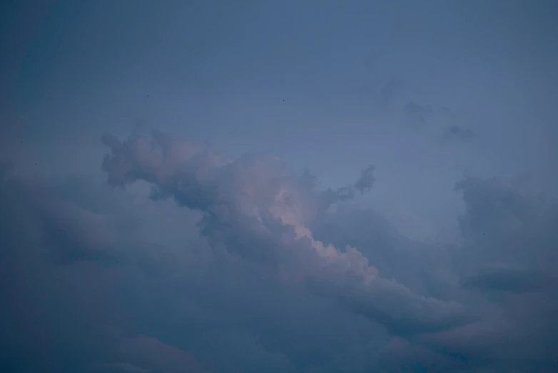 a airplane flying through a gray cloudy sky