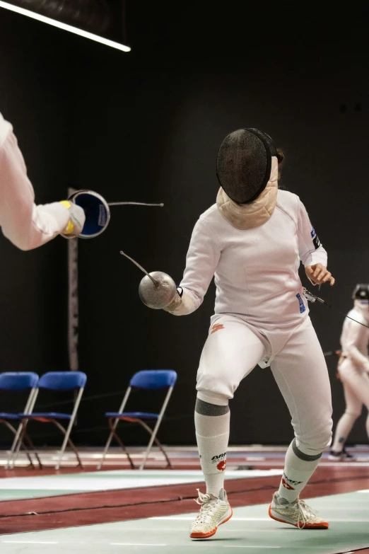 young woman with short hair engaged in fencing