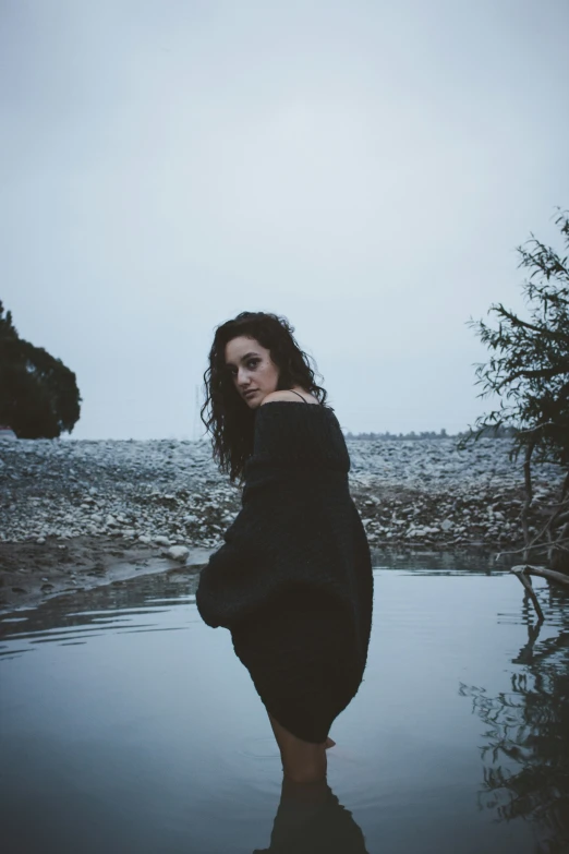 the girl standing alone with her long black dress on