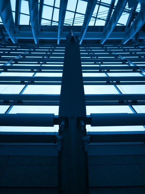 an upward s looking at the blue sky in the glass building