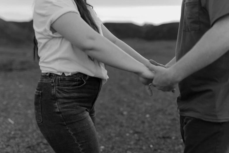 black and white image of two people holding hands